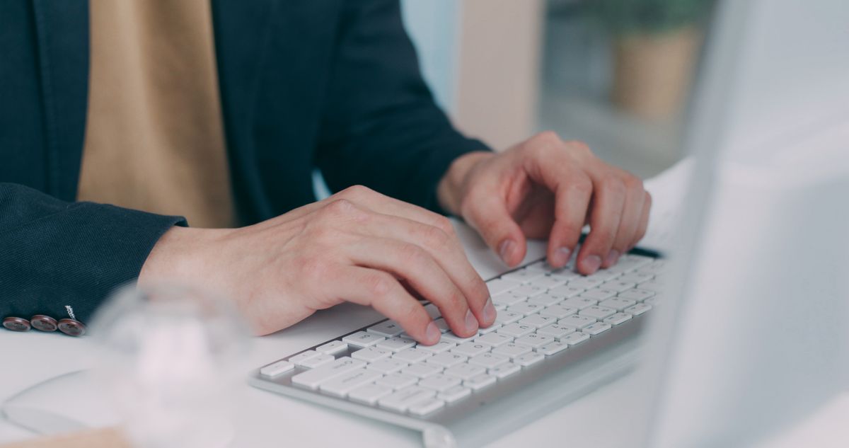 Hands typing on a keyboard while processing records