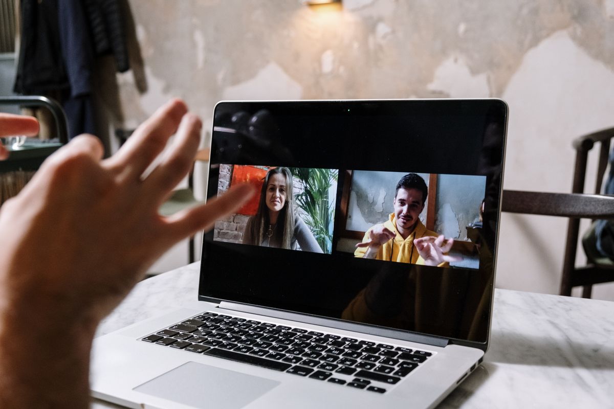 Two colleagues on a video call using a laptop