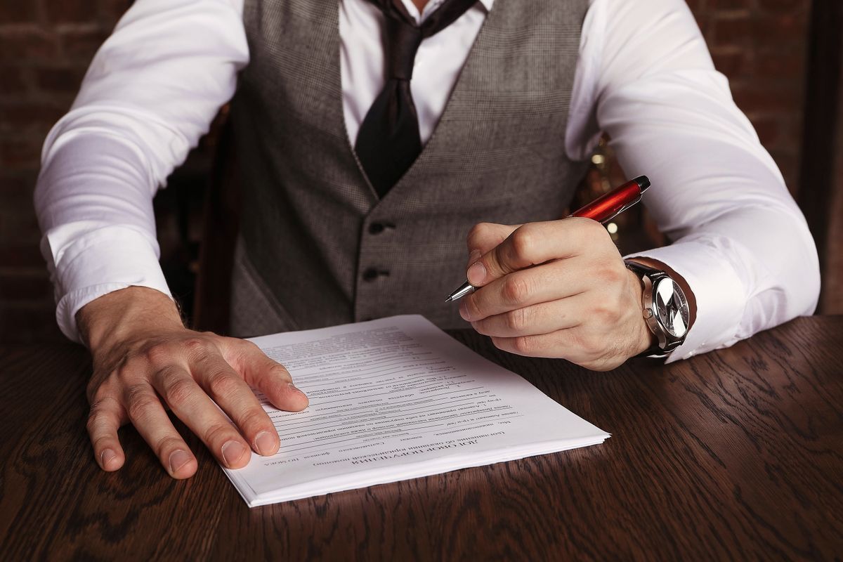 Business owner signing a contract at a desk