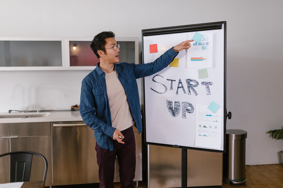 Man pointing at notes on a whiteboard