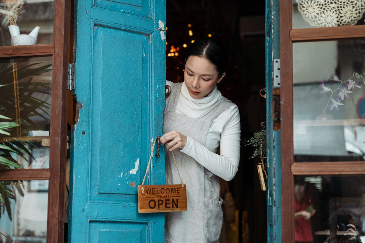 Small business owner hanging a sign on the door